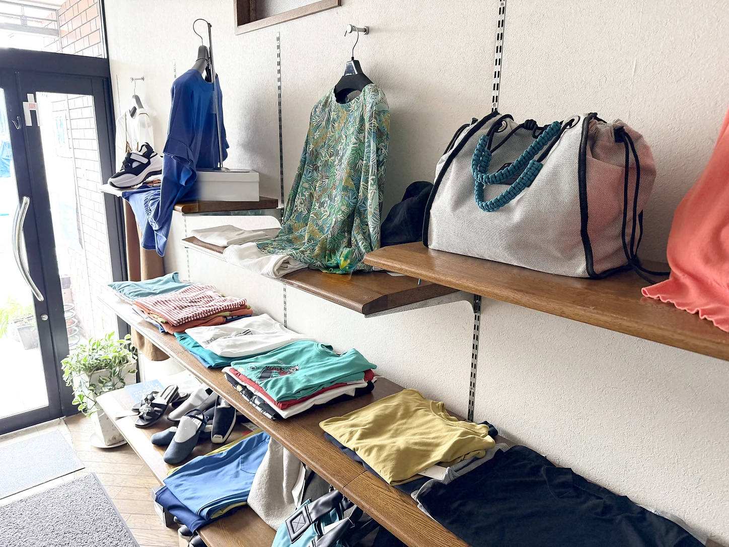 色とりどりの洋服やバッグが並ぶ店内の棚
